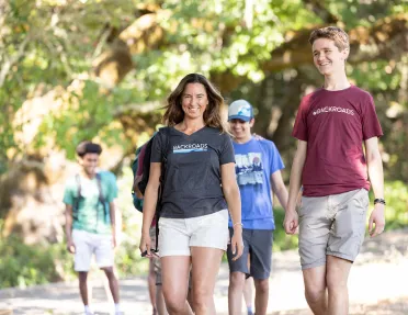 Group of guests walking on trail, one smiling at camera.