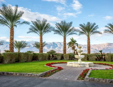 Courtyard with a stone fountain and grass area