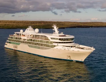 Exterior view of large cruise ship with an open valley in the background